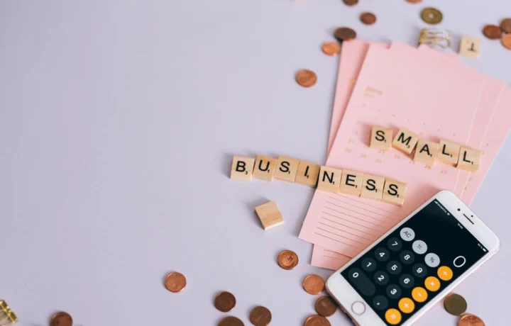 Cena de planejamento de uma pequena empresa com moedas, calculadora de smartphone e letras em um fundo organizado