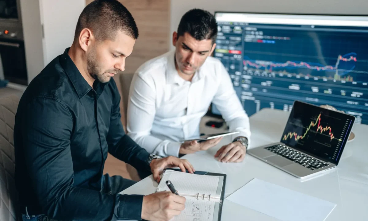 Empresários analisam indicadores financeiros em gráficos digitais, exemplo prático de ferramentas de gestão