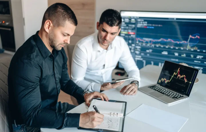 Empresários analisam indicadores financeiros em gráficos digitais, exemplo prático de ferramentas de gestão